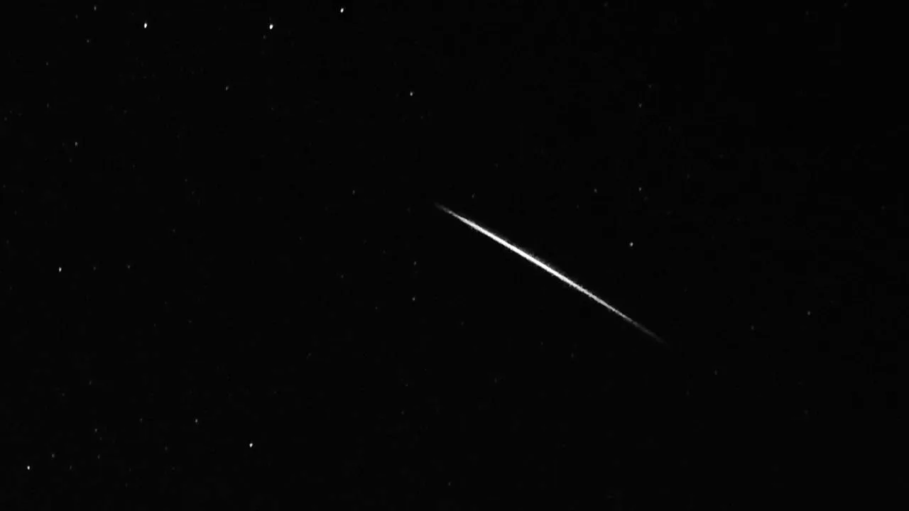 A short, bright meteor streak with stars around it.