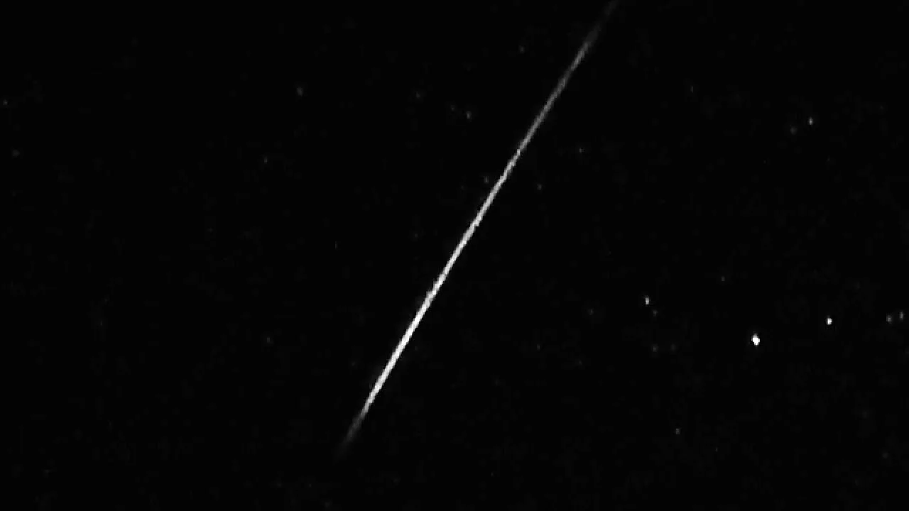 A long meteor streak running from upper right to lower left through the stars.