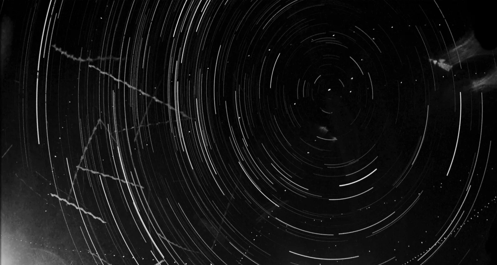 Real star trails from one TwilightScan camera, circling Polaris, with plane strobes and satellites crossing.